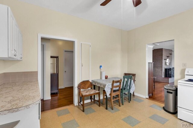 dining room with ceiling fan, light floors, and baseboards