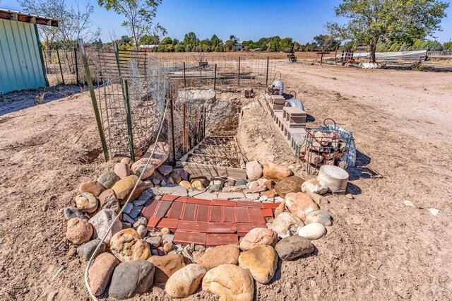 view of yard with fence and a rural view