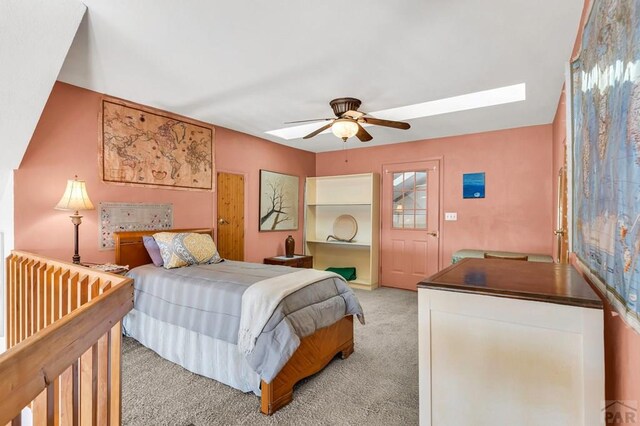 bedroom featuring light carpet, a skylight, and ceiling fan