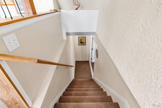 stairs with baseboards and a textured wall