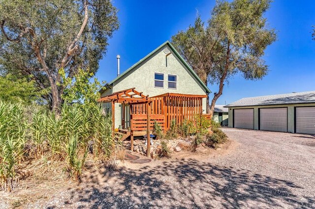 view of front of house with stucco siding and a pergola