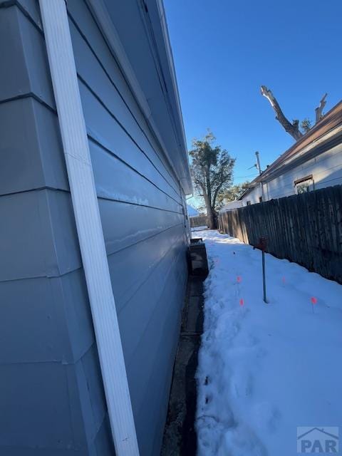 view of snowy exterior with fence