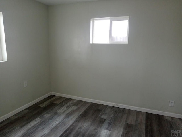 empty room with baseboards and dark wood finished floors