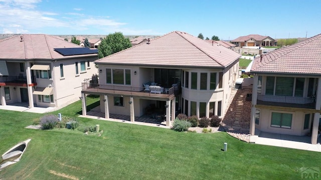 rear view of house with a residential view, a patio, a tiled roof, and stucco siding