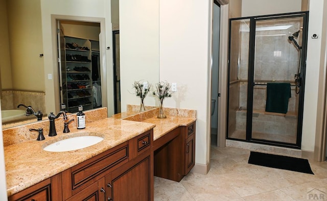 bathroom with a spacious closet, tile patterned flooring, a shower stall, and vanity