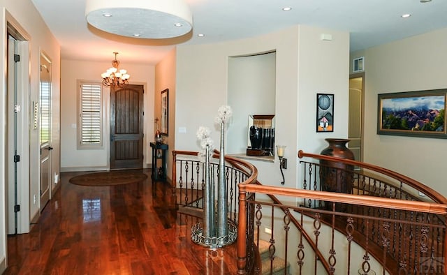 entryway featuring baseboards, dark wood finished floors, a notable chandelier, and recessed lighting