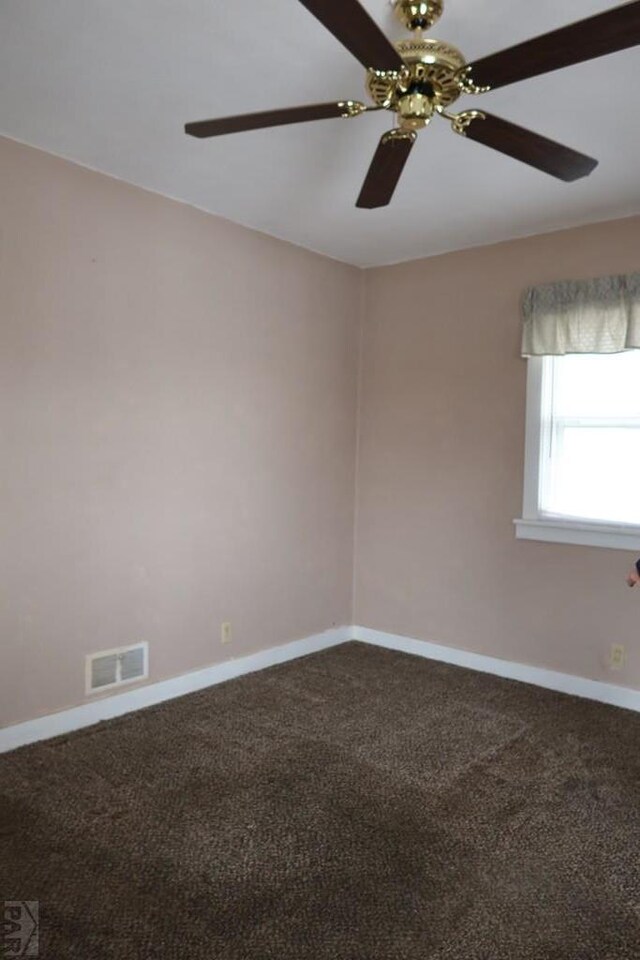 empty room with carpet, visible vents, and baseboards