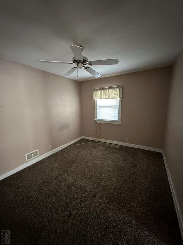 carpeted spare room with a ceiling fan, visible vents, and baseboards