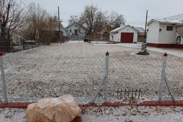 view of yard with a garage, an outbuilding, and fence