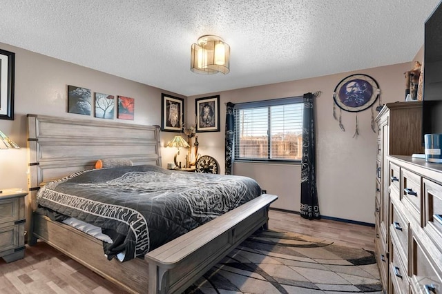 bedroom featuring light wood-style flooring and a textured ceiling