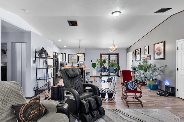 living area featuring a chandelier, visible vents, and wood finished floors