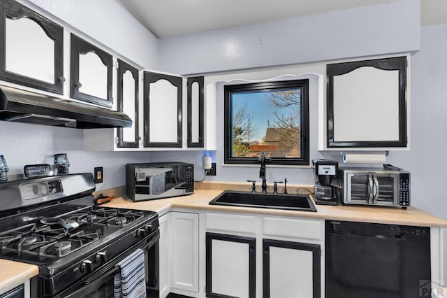 kitchen featuring a sink, under cabinet range hood, range with gas stovetop, black dishwasher, and light countertops