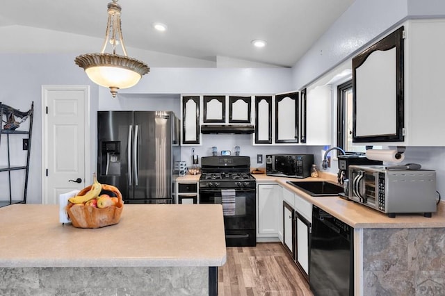 kitchen with lofted ceiling, a sink, black appliances, light countertops, and under cabinet range hood