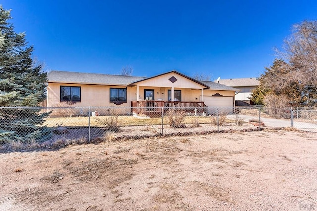 ranch-style house featuring a garage and a fenced front yard