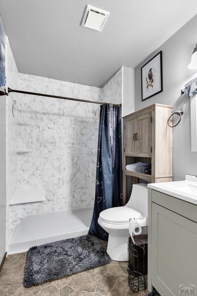 bathroom with vanity, a shower stall, toilet, and visible vents