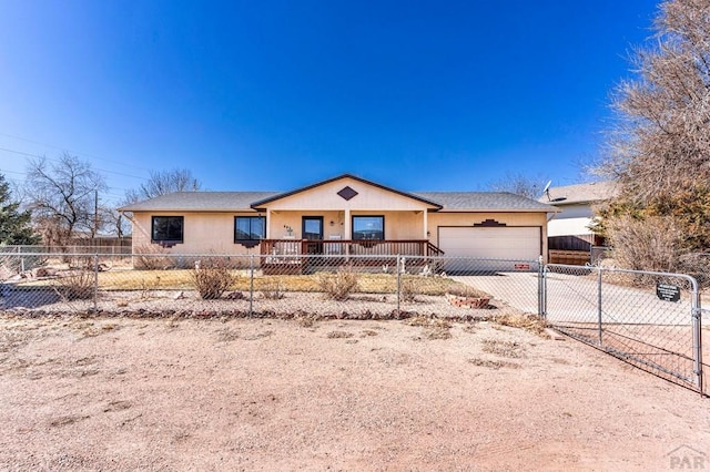 ranch-style house featuring a gate, an attached garage, driveway, and a fenced front yard