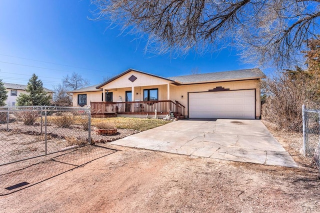 ranch-style house featuring a fenced front yard, covered porch, concrete driveway, and a garage