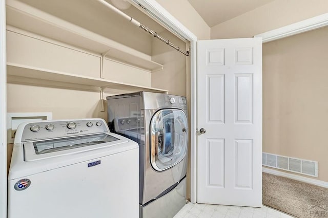 laundry area with laundry area, visible vents, washer and clothes dryer, and light floors