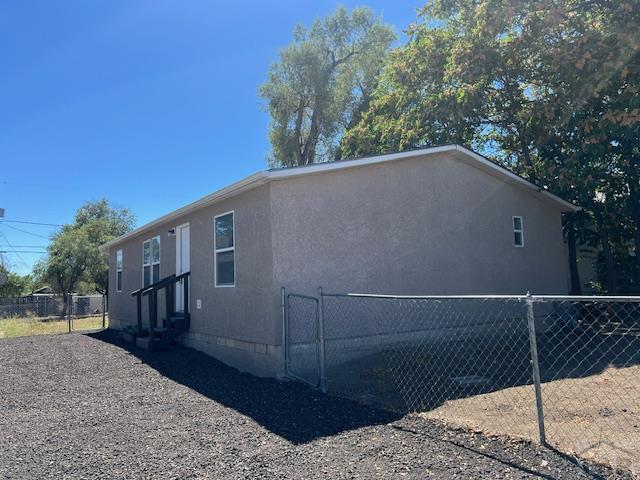 view of home's exterior with entry steps, fence, and stucco siding