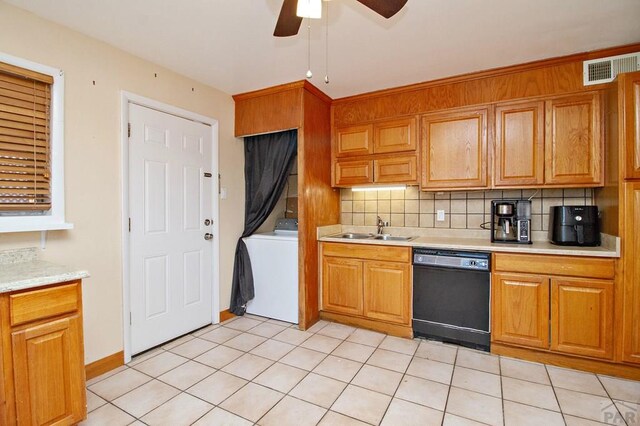 kitchen featuring a sink, light countertops, decorative backsplash, dishwasher, and washer / dryer