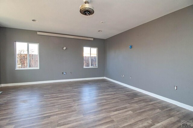 empty room with baseboards and wood finished floors