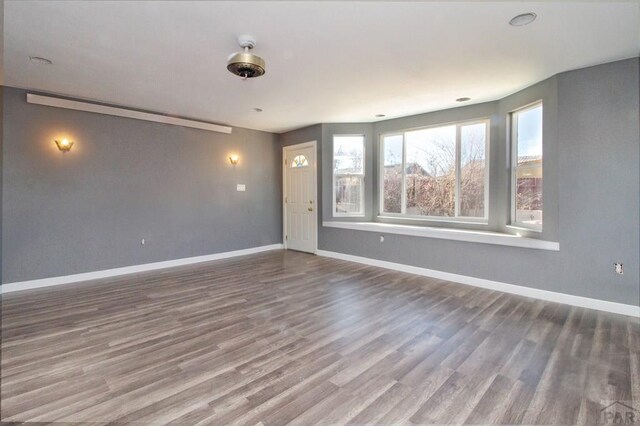 unfurnished room featuring dark wood-style floors and baseboards