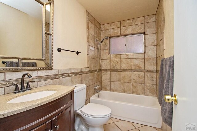 full bathroom featuring toilet, vanity, tile patterned flooring, shower / bathtub combination, and tile walls