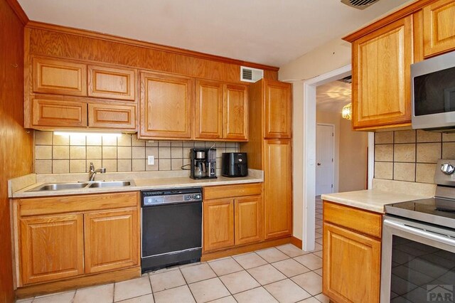 kitchen featuring stainless steel appliances, tasteful backsplash, light countertops, visible vents, and a sink