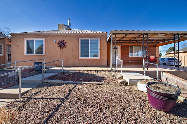 view of front facade with a standing seam roof, fence, metal roof, and stucco siding