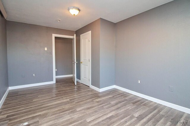 spare room featuring light wood-type flooring and baseboards