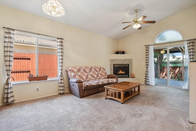 living room featuring lofted ceiling, carpet, a fireplace, and a ceiling fan