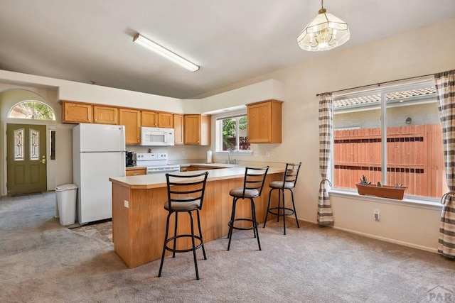 kitchen featuring light carpet, white appliances, a peninsula, and light countertops