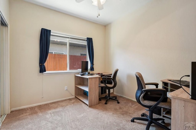 carpeted office featuring ceiling fan and baseboards