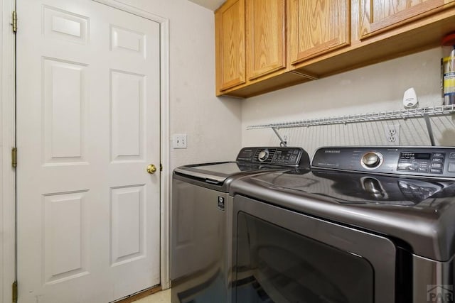 laundry area featuring washer and clothes dryer and cabinet space