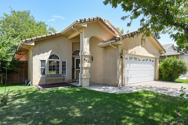 mediterranean / spanish-style house with a garage, concrete driveway, stucco siding, fence, and a front yard