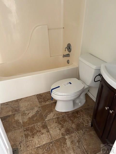 bathroom with washtub / shower combination, vanity, and toilet