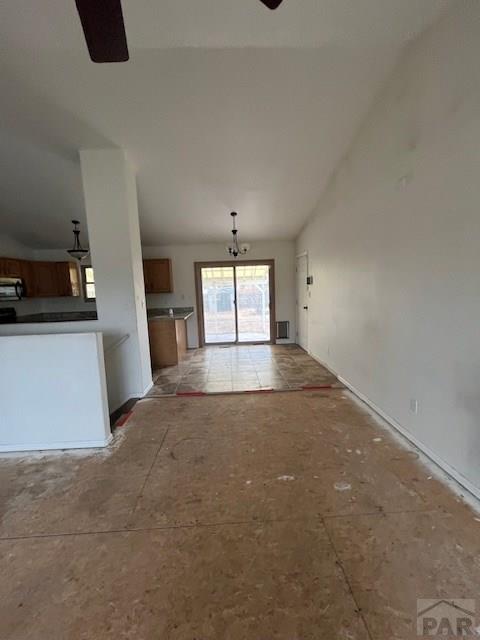 unfurnished living room with ceiling fan and vaulted ceiling