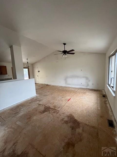 unfurnished living room featuring vaulted ceiling, a ceiling fan, visible vents, and a healthy amount of sunlight