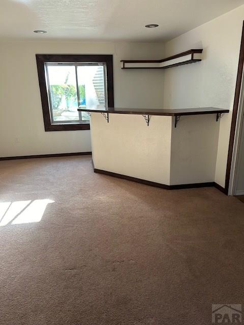 empty room featuring carpet and baseboards