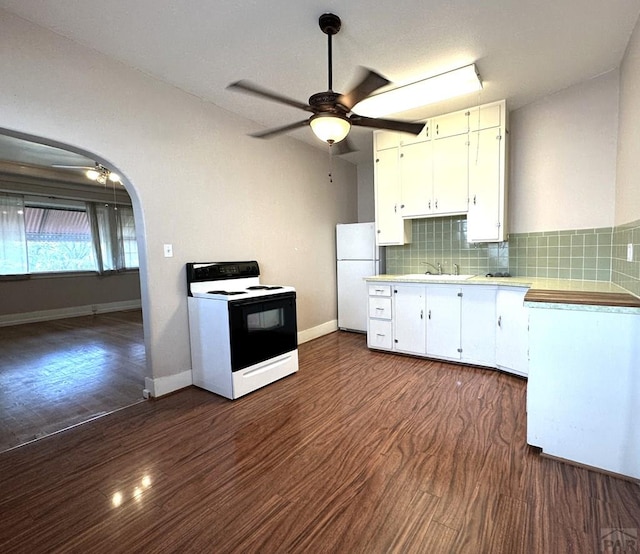 519 Broadway Ave, Pueblo, CO 81004 - kitchen with arched walkways, range with electric stovetop, white cabinetry, freestanding refrigerator, and tasteful backsplash
