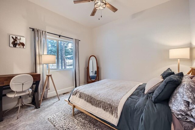 carpeted bedroom with ceiling fan and baseboards