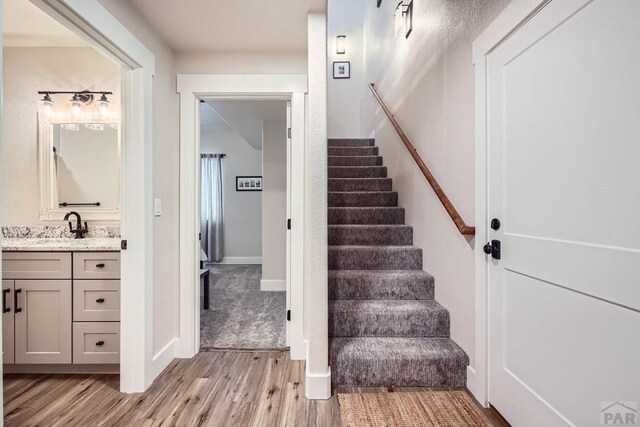 staircase featuring baseboards and wood finished floors