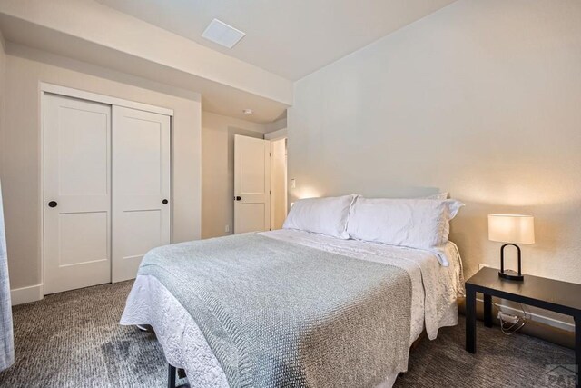 bedroom featuring dark colored carpet and a closet