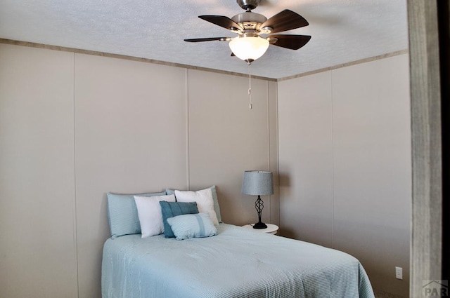 bedroom with a ceiling fan and a textured ceiling