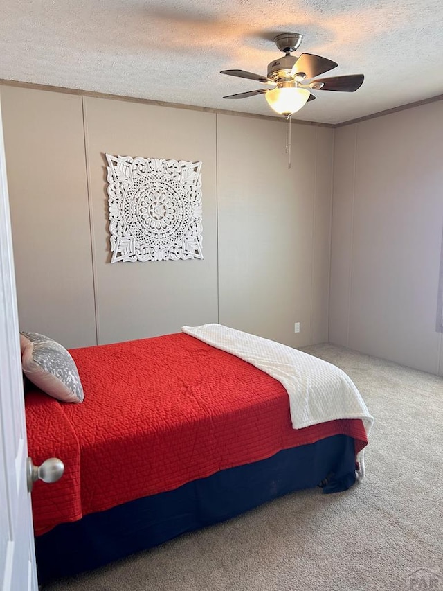 bedroom featuring a textured ceiling, carpet floors, and ceiling fan