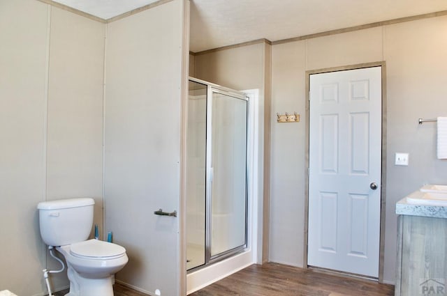 full bathroom with toilet, a stall shower, wood finished floors, and vanity