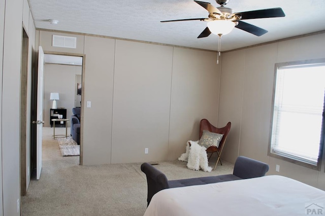 bedroom with light colored carpet, visible vents, and ceiling fan