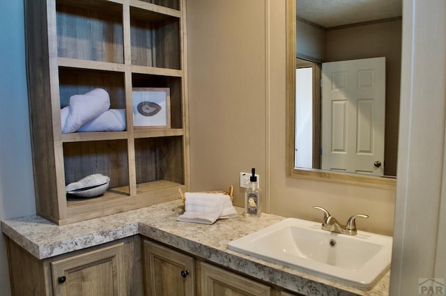 bathroom with ornamental molding and vanity