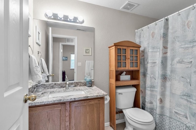 bathroom with visible vents, vanity, and toilet