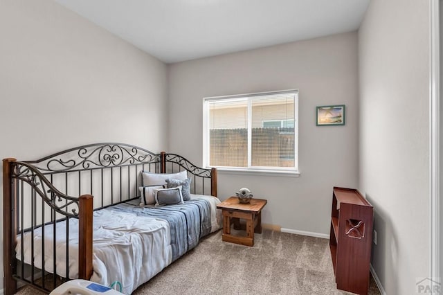 bedroom featuring light carpet and baseboards